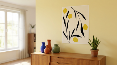 Kunstplakat med citroner og sorte blade på gul væg over en skænk i stuen