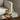 Grøn urtepotteskjuler med rosa sløjfe på sidebord med bog og lampe