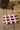 Pink bordskåner fra klevering, på genbrugstræ med messingbakke